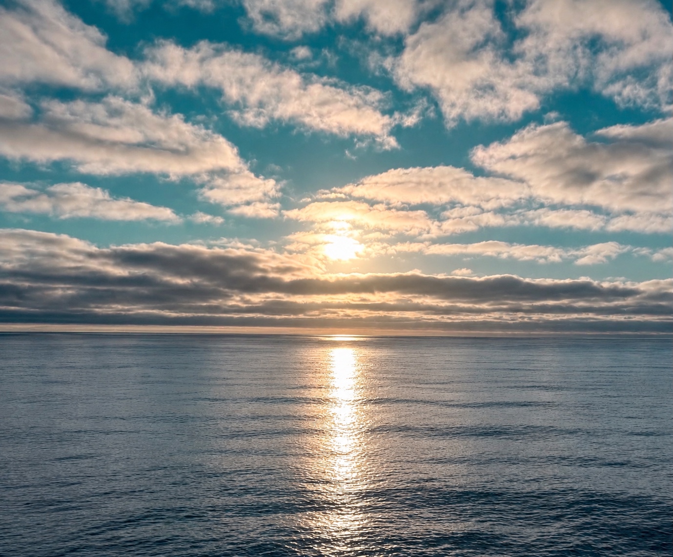 Soft sunlight breaking through clouds over the sea